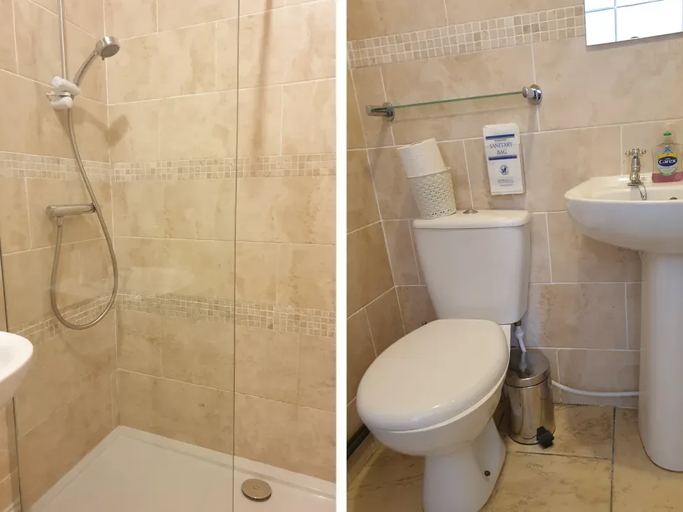 A tiled bathroom with a shower, toilet, and sink.