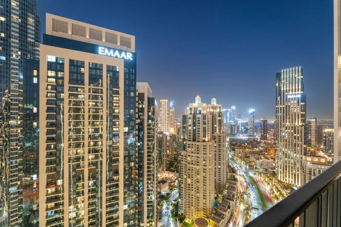 A nighttime city skyline with illuminated high-rise buildings and streets.
