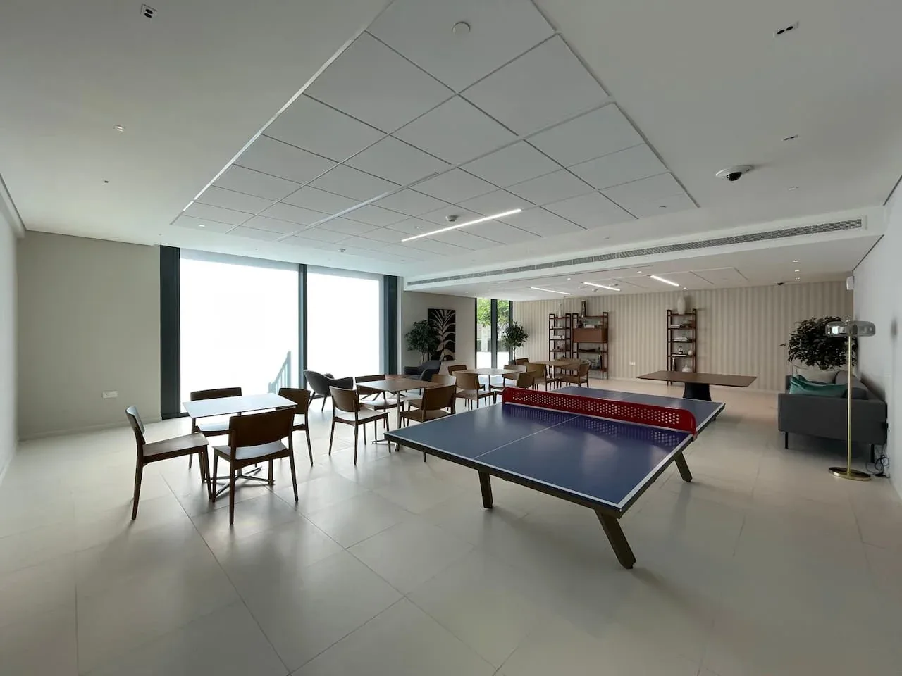 A recreation room features a table tennis table and dining seating.