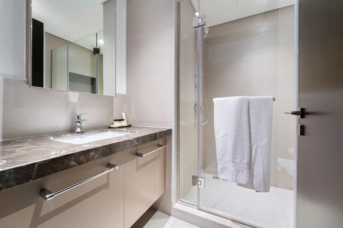 A modern bathroom with a long vanity and a glass shower.