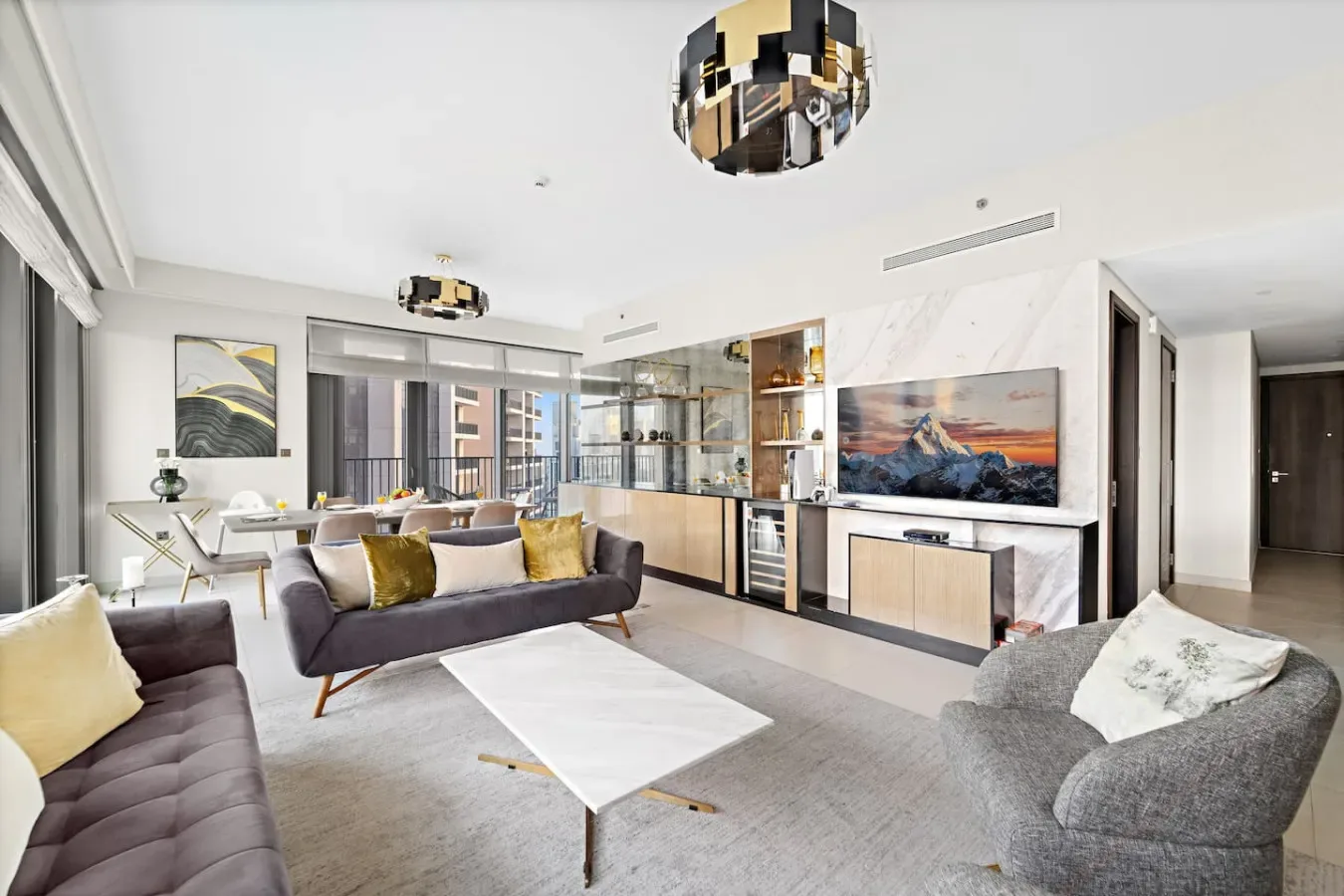 A bright living room with seating, a coffee table, and a television.