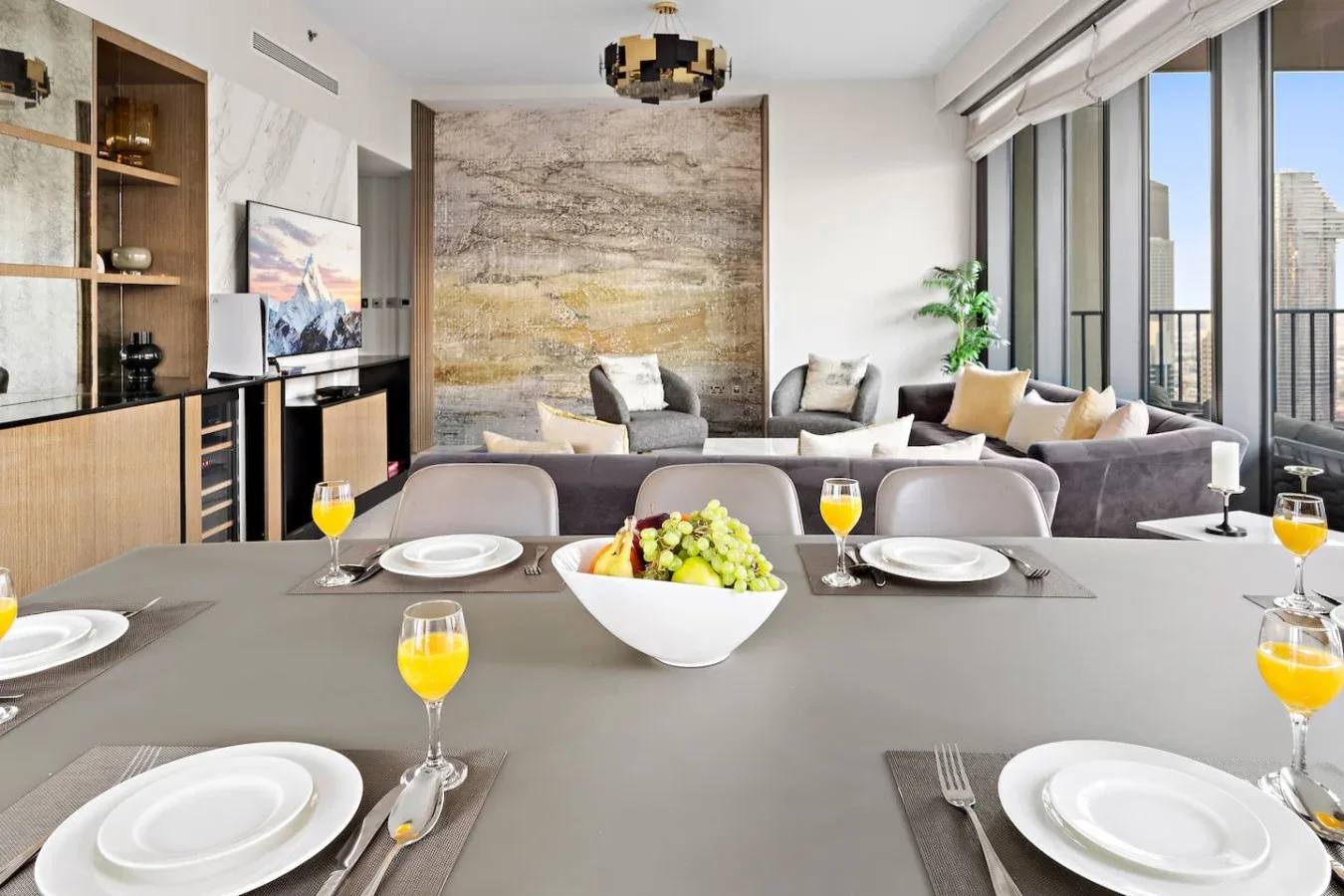 A dining area opens onto a living room with large windows.