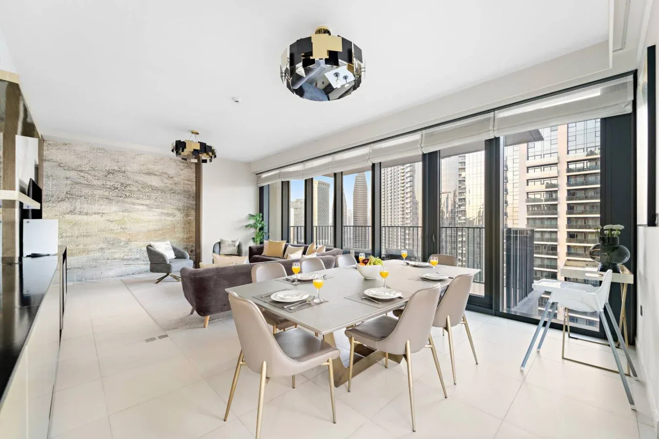 A bright dining area with a set table beside floor-to-ceiling windows.