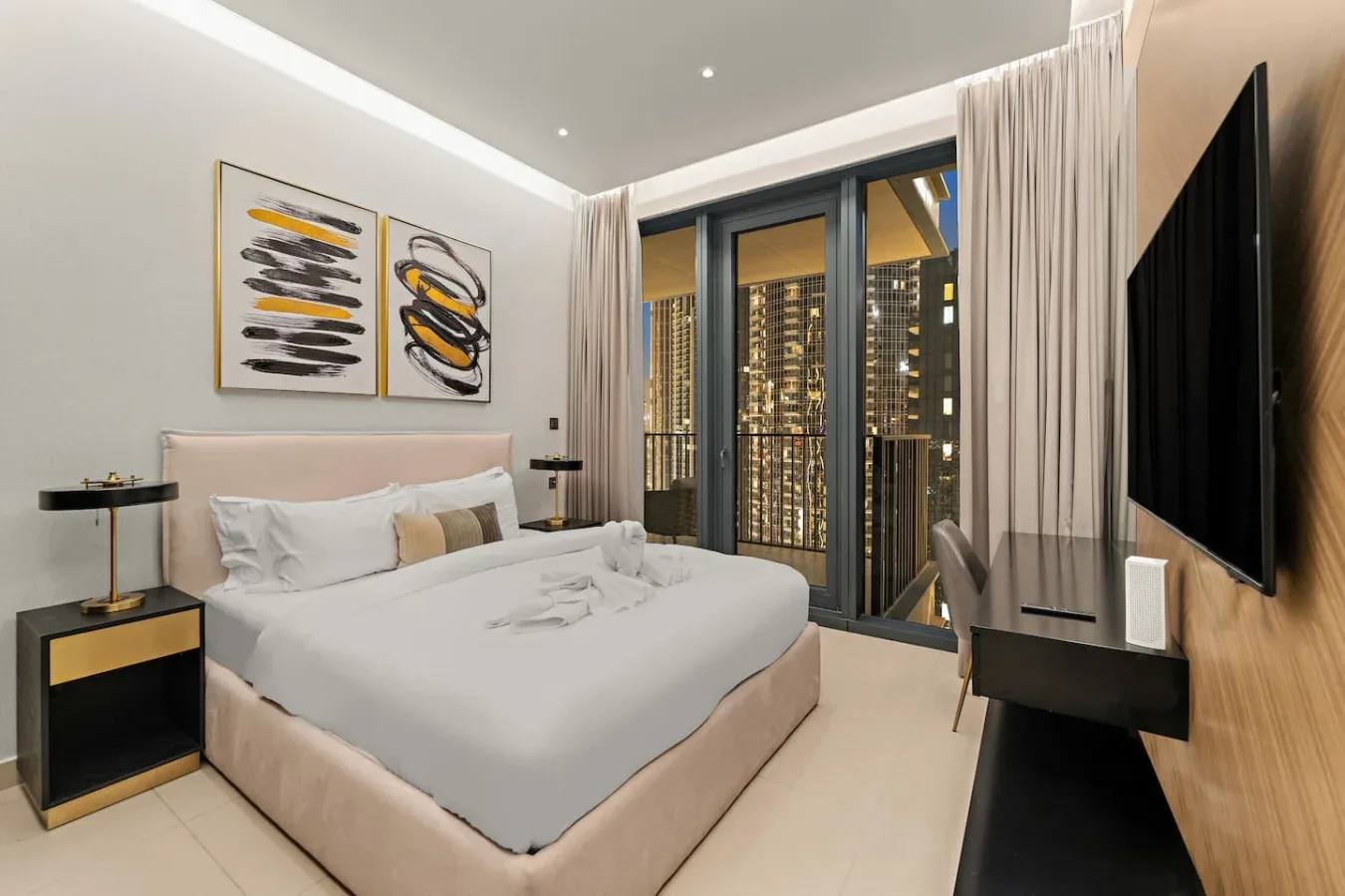 A bedroom with a neatly made bed and floor-to-ceiling windows.