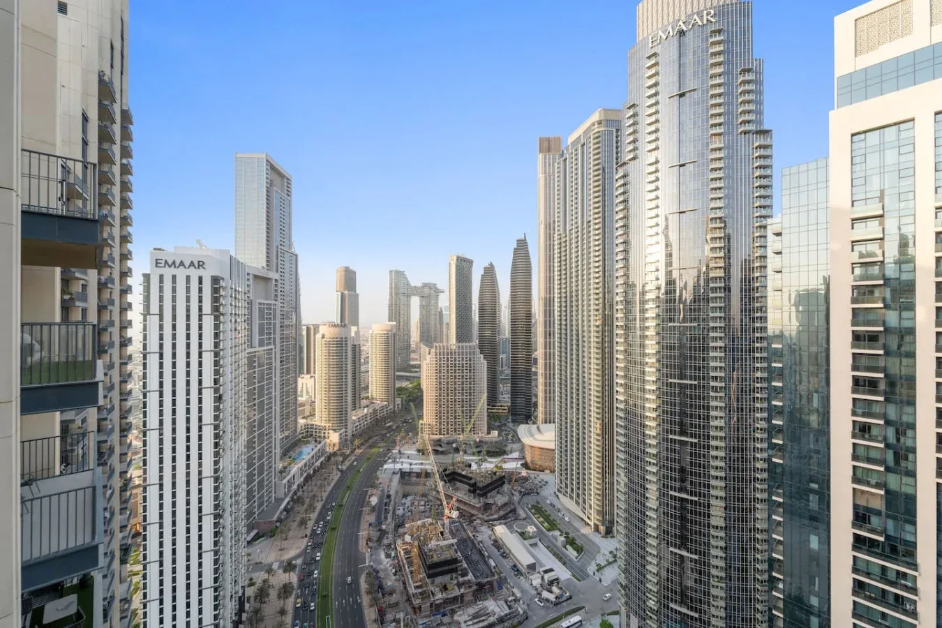 A city skyline of tall buildings under a clear blue sky.