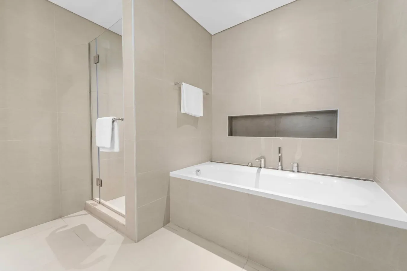 A bright bathroom with a bathtub and walk-in shower.