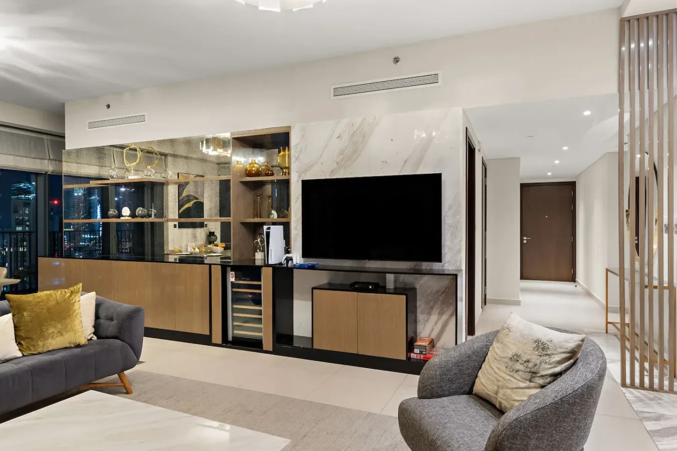 A modern living room with a television, a sofa, and a lounge chair.