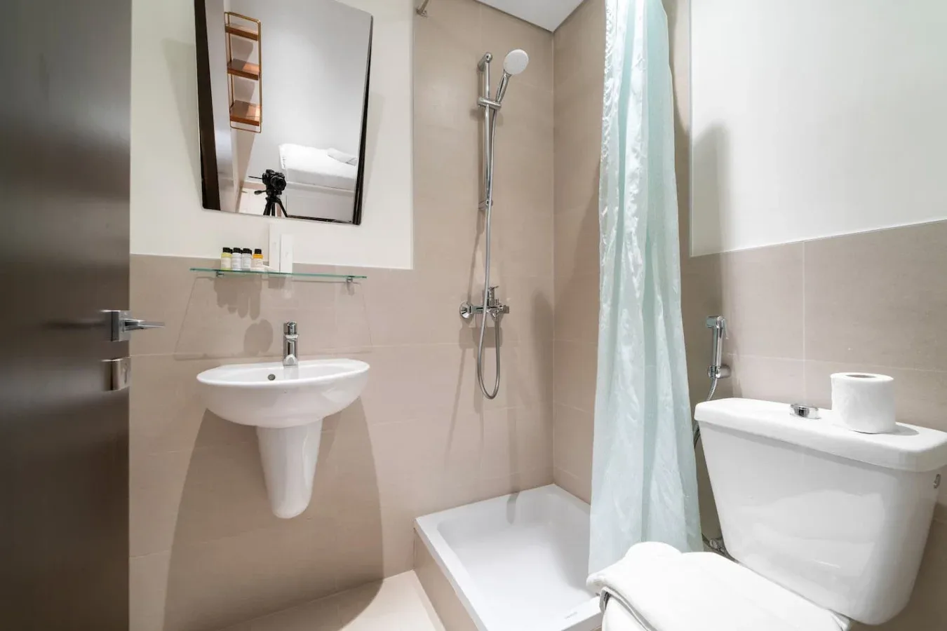 A bathroom with a sink, shower, and toilet.