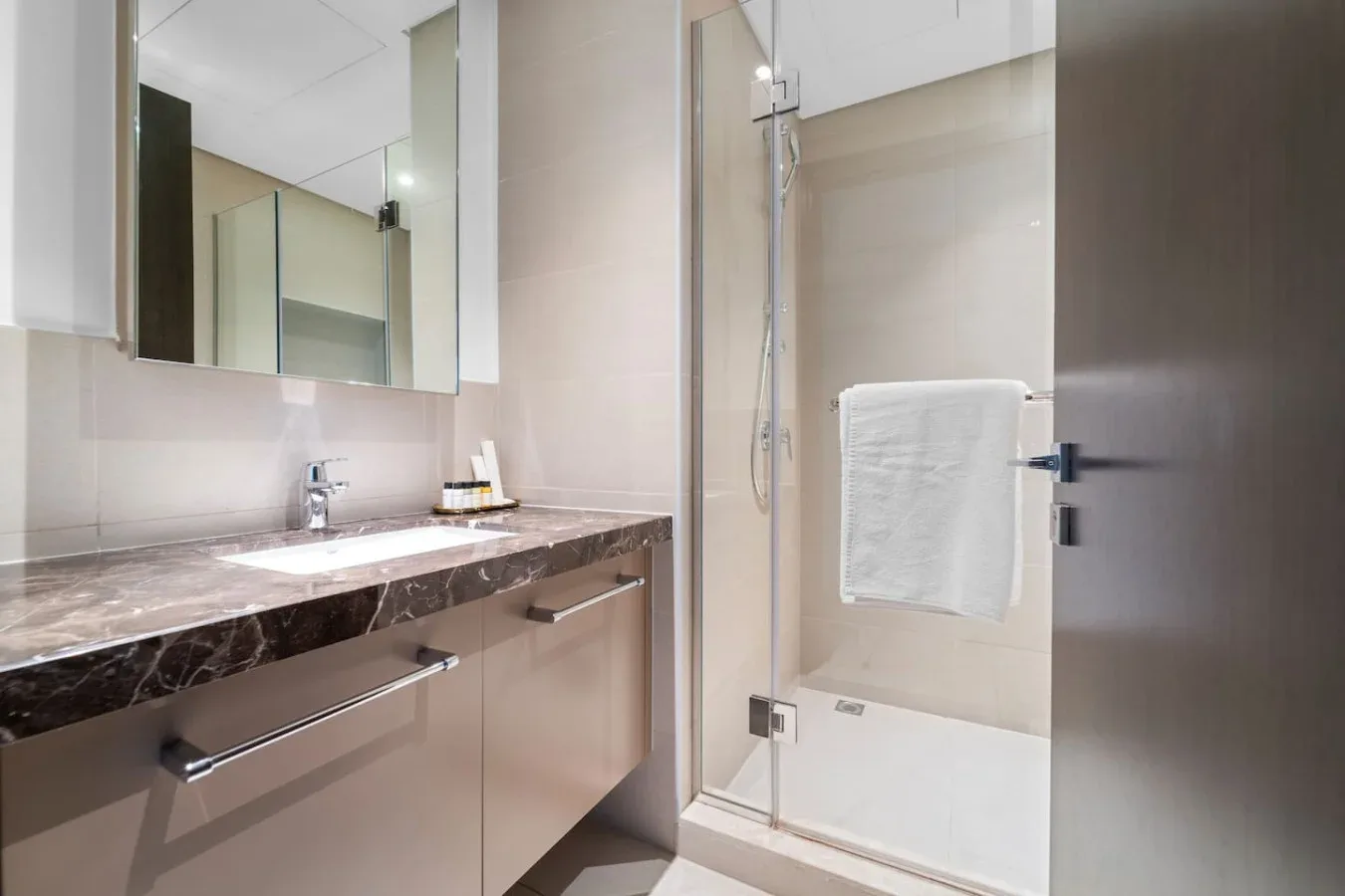 A bathroom vanity with a sink and a glass shower.