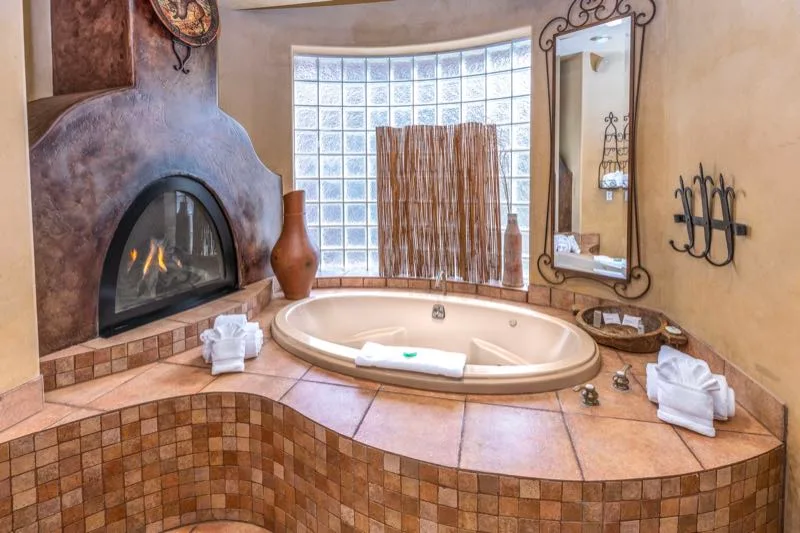 Bañera de hidromasaje junto a una chimenea en Sedona Breeze