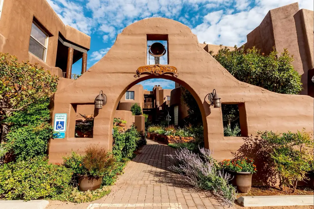 Arco de entrada de Adobe Grand Villas con lavanda y plantas en macetas
