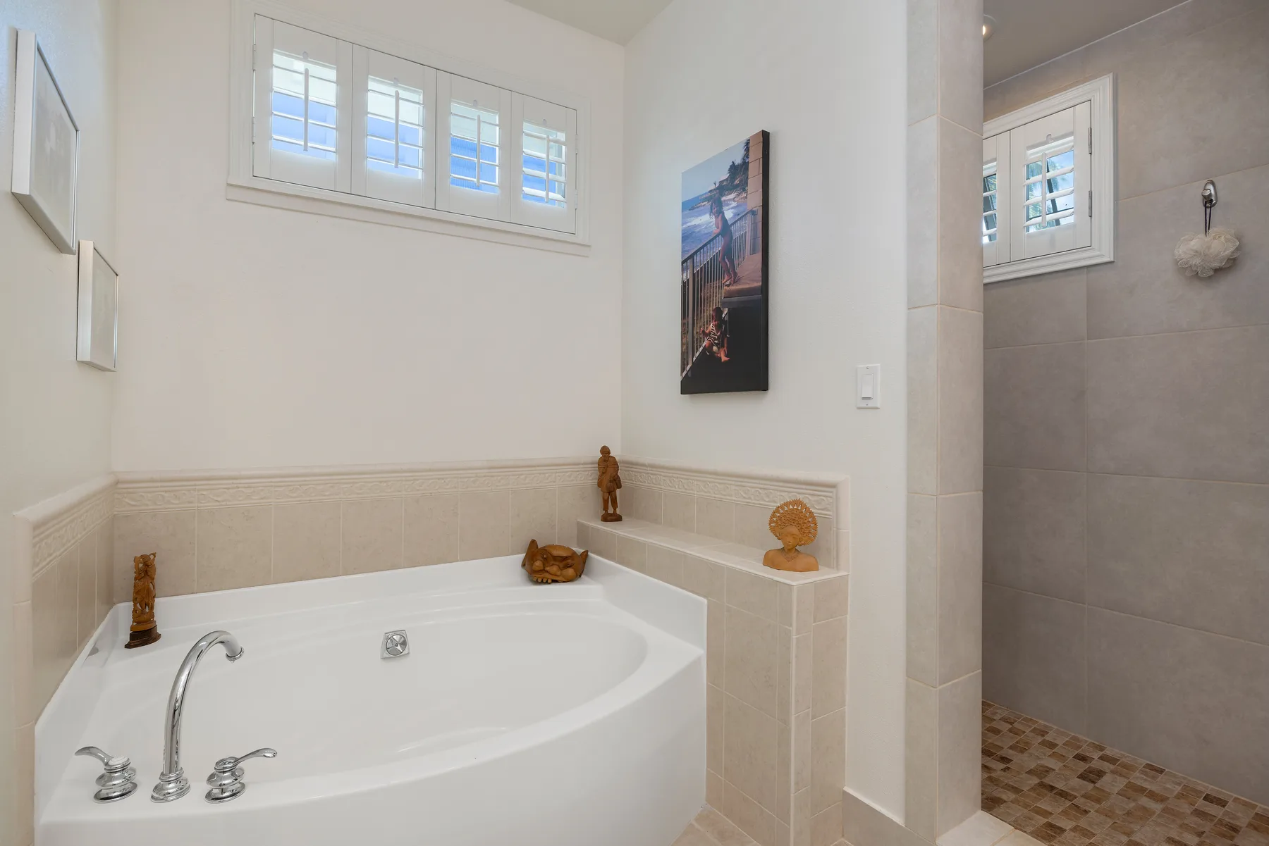 Un baño con una bañera esquinera empotrada y una zona de ducha con azulejos.
