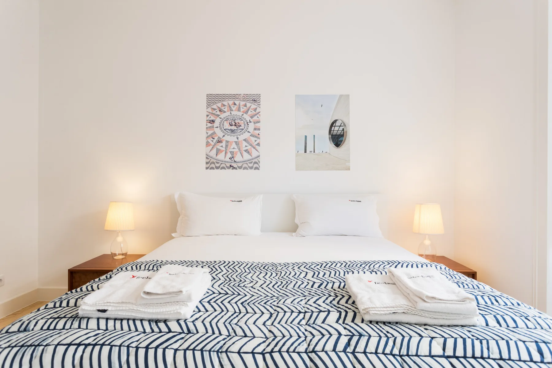 A bedroom with a bed dressed in blue and white patterned bedding.