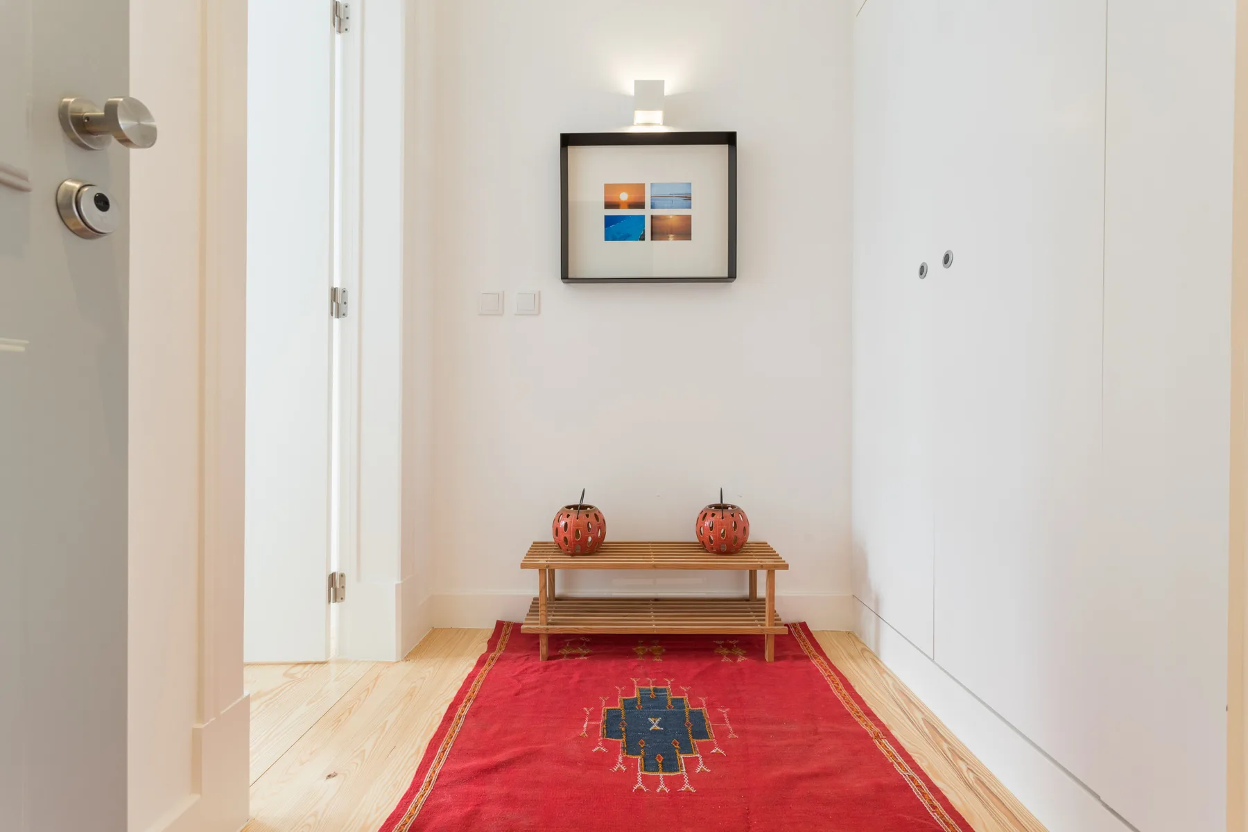 A bright hallway with a red runner rug and a small console table.