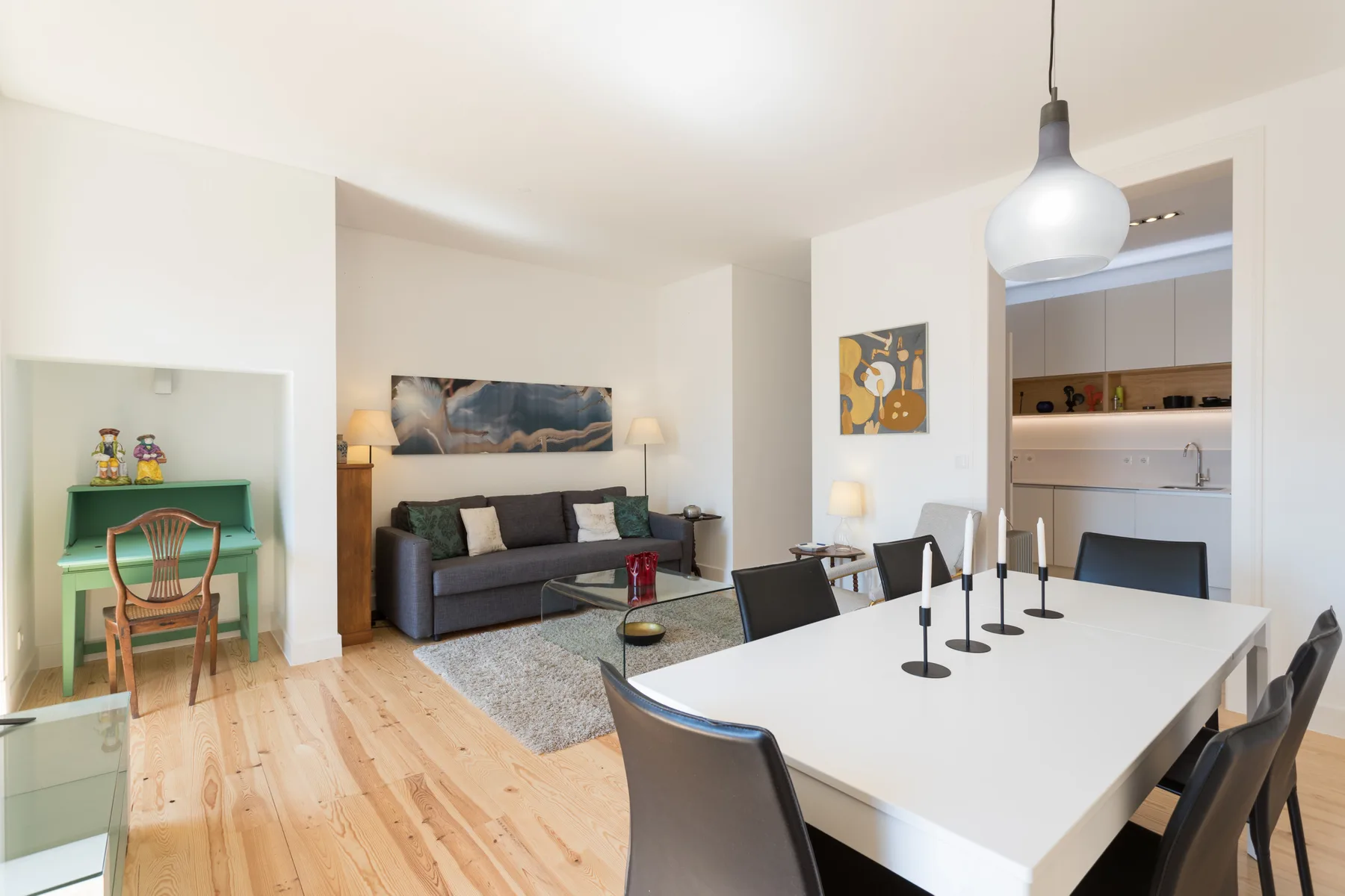 Una luminosa sala de estar y comedor diáfana, con sofá y una mesa grande.