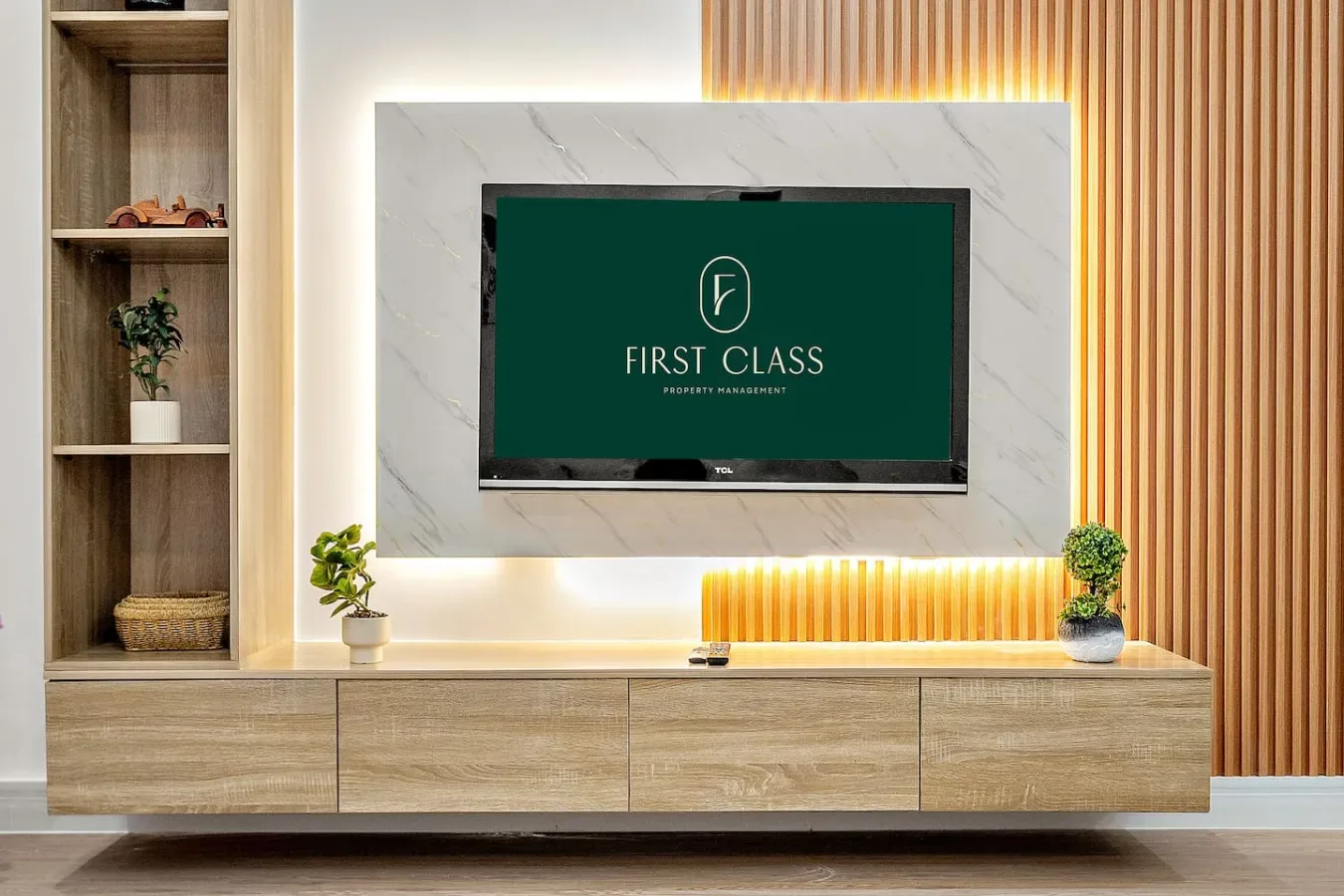 Una pared de entretenimiento en una sala de estar con un televisor sobre un mueble bajo de madera.
