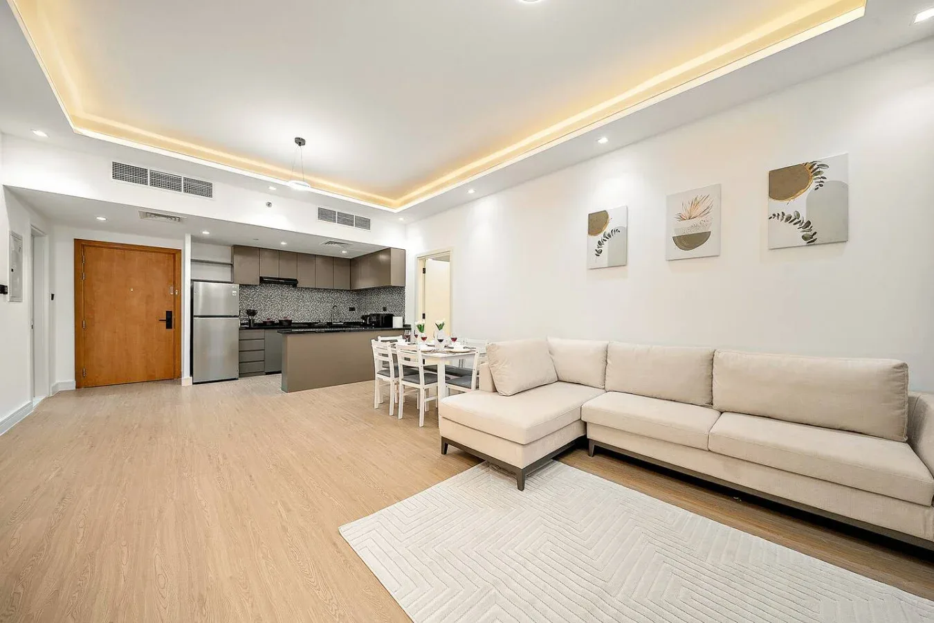 Una sala-comedor de concepto abierto con sofá seccional y cocina.
