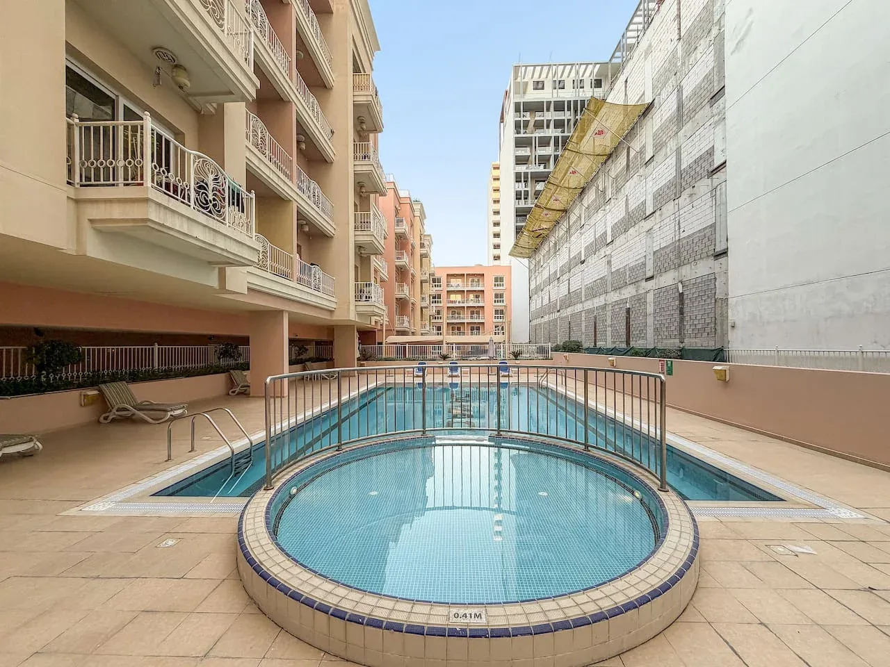 Una piscina al aire libre está entre edificios de apartamentos.