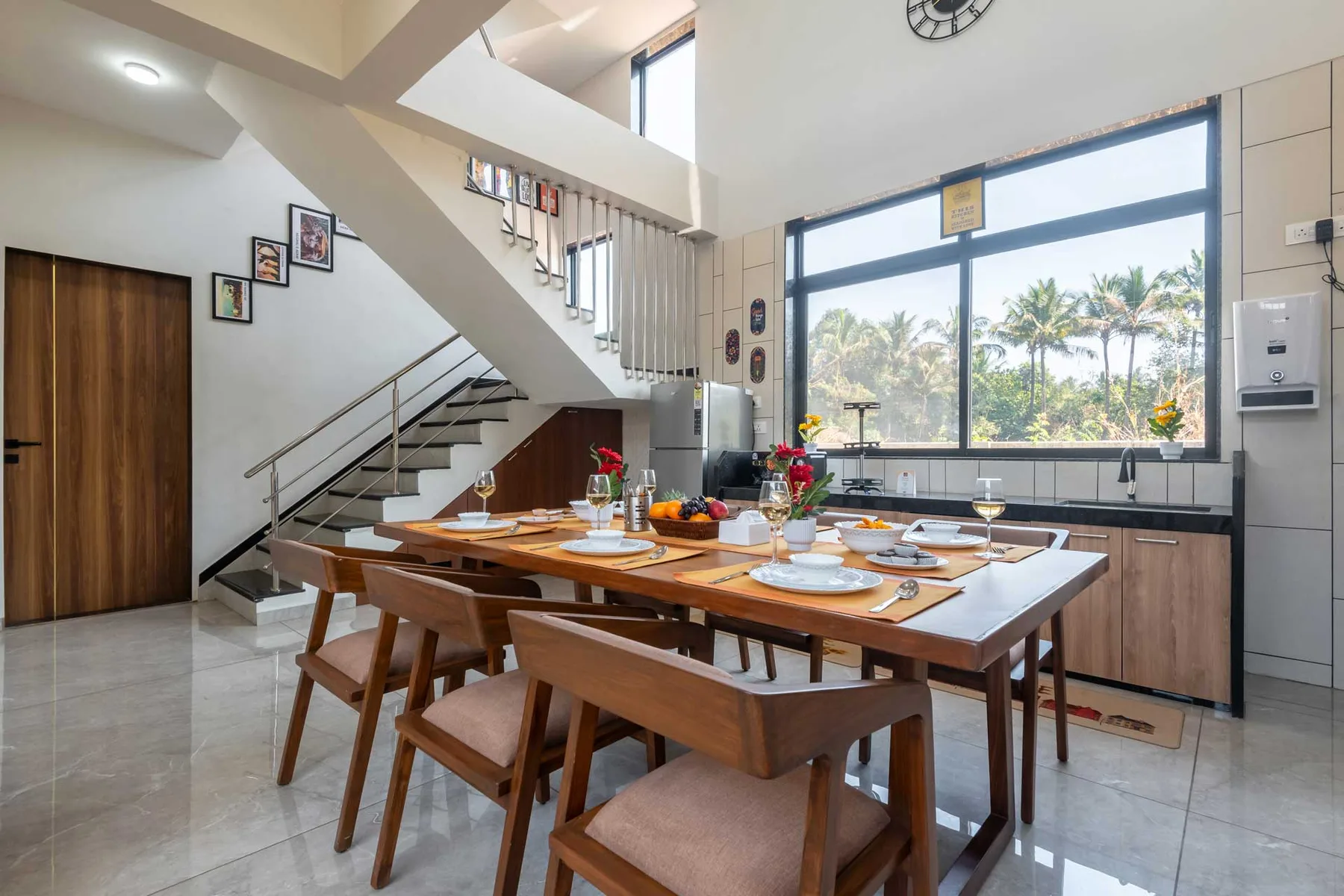Un comedor con una mesa larga puesta junto a una ventana grande.