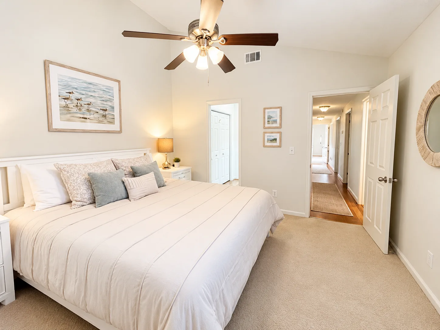 A bedroom with a large bed, bedside tables, and a ceiling fan.