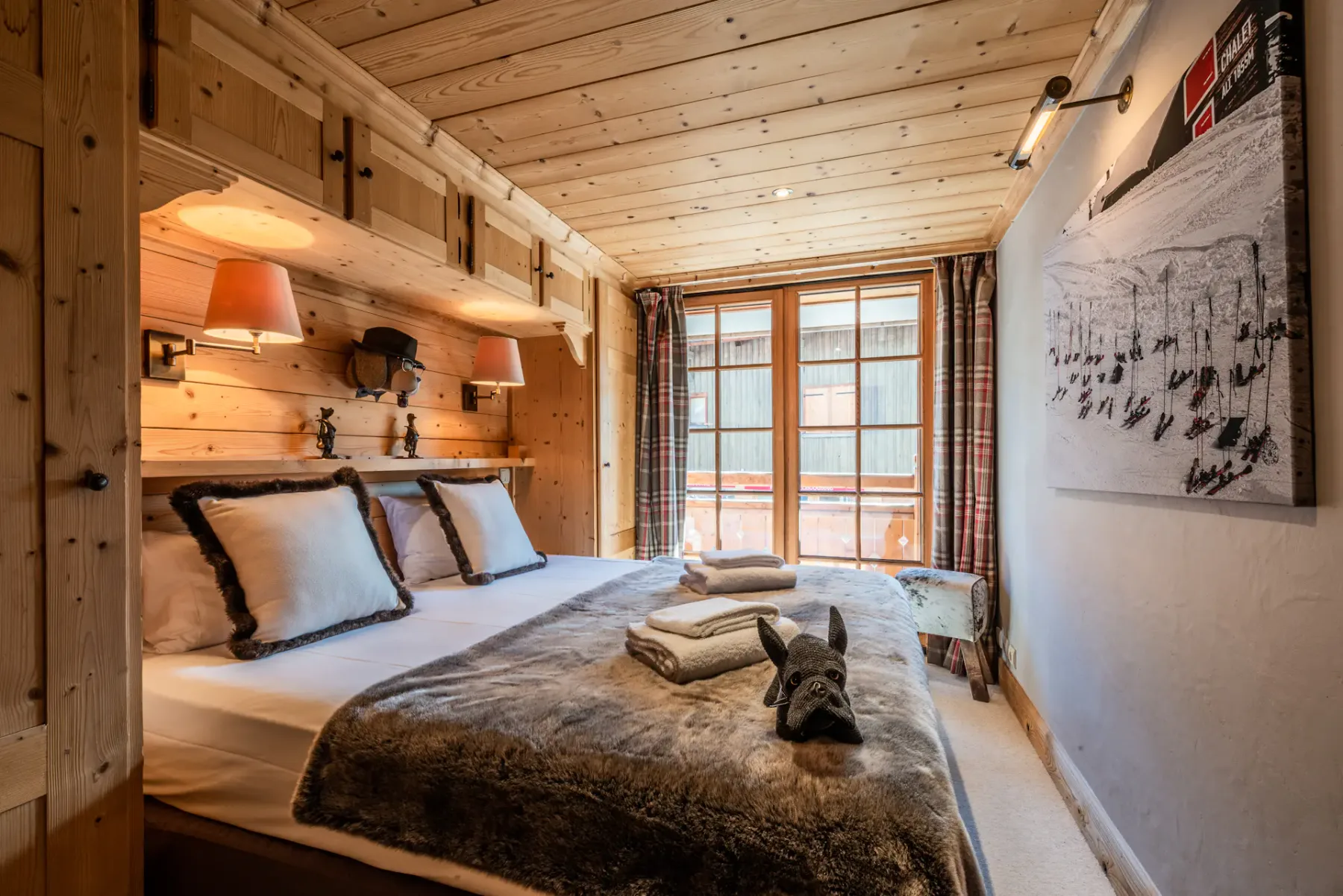 A wood-paneled bedroom with a double bed and a large window.