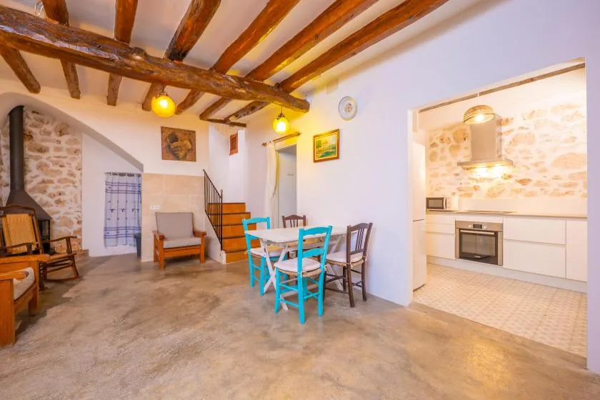 Un comedor y sala de estilo rústico se abren a una cocina luminosa.