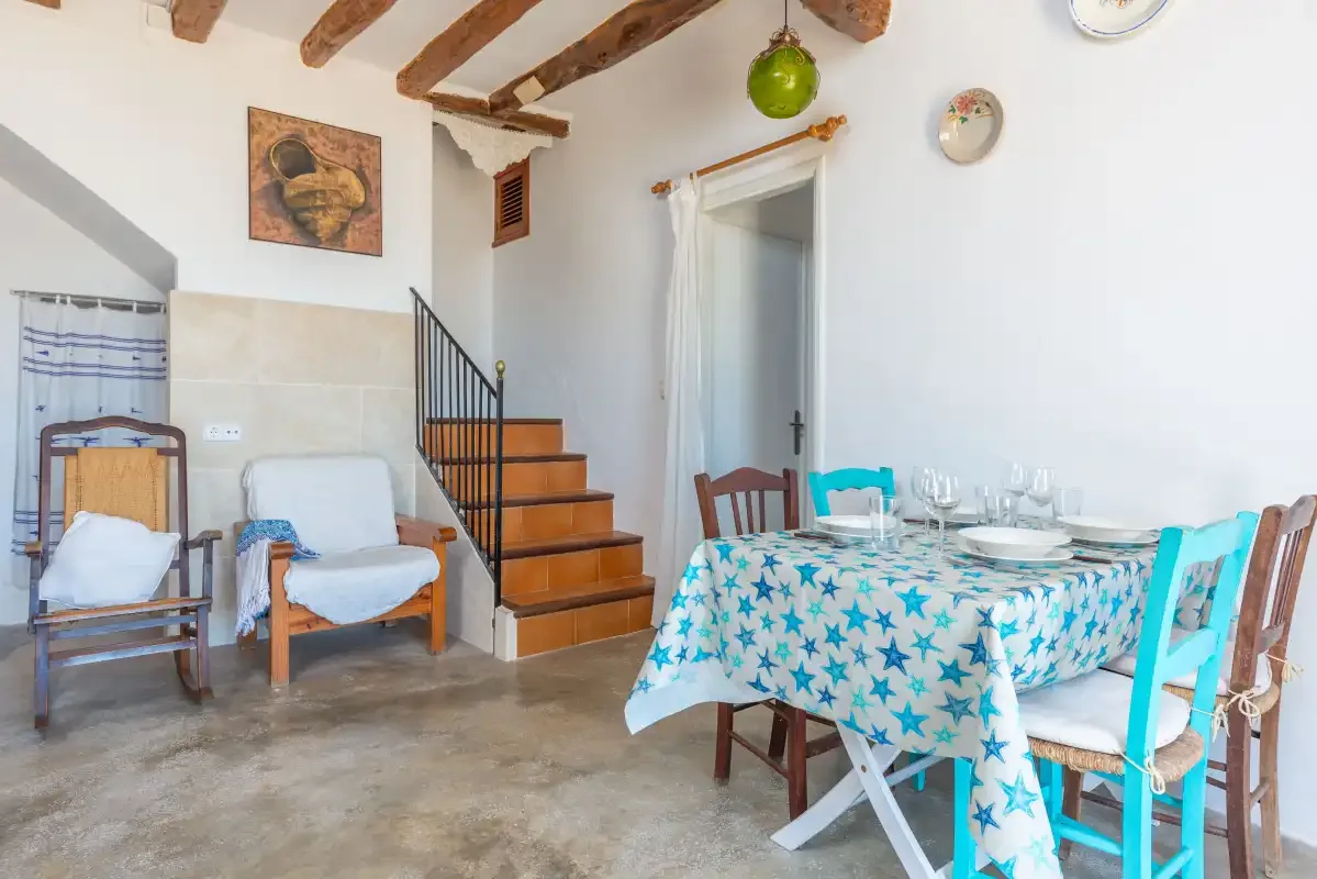 Un comedor con una mesa puesta junto a una escalera de madera.