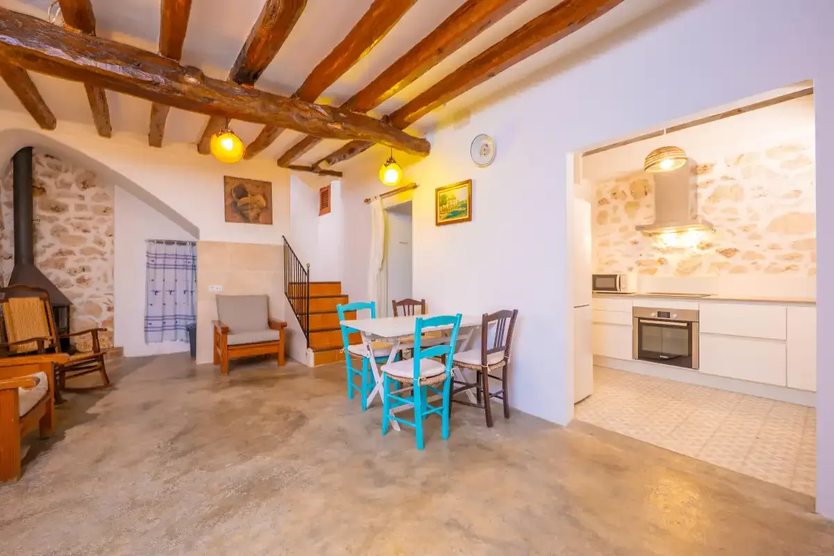 Una zona rústica de estar y comedor se abre a una cocina luminosa.