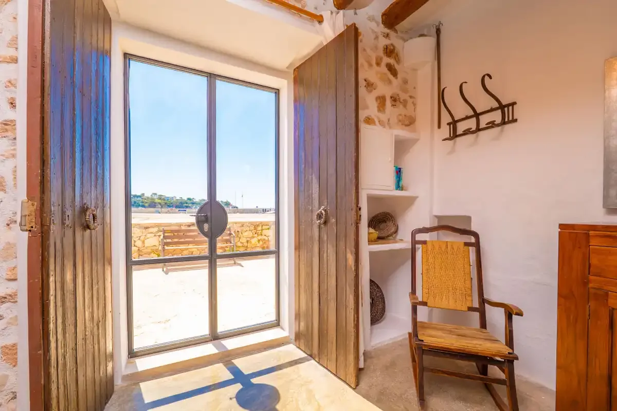 Una habitación luminosa con una puerta de vidrio que da a un balcón.