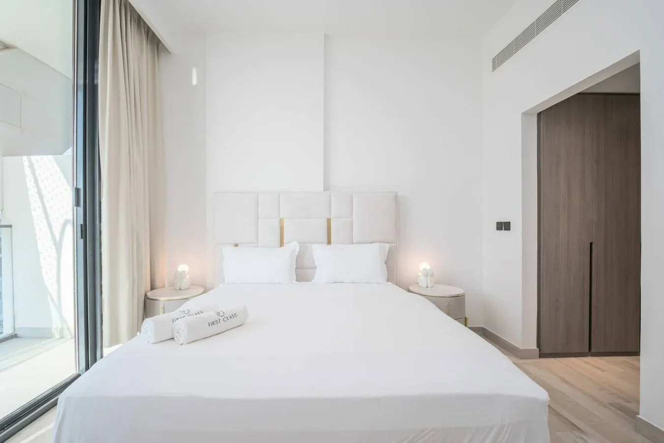 Un dormitorio luminoso con una cama bien tendida y mesitas de noche.