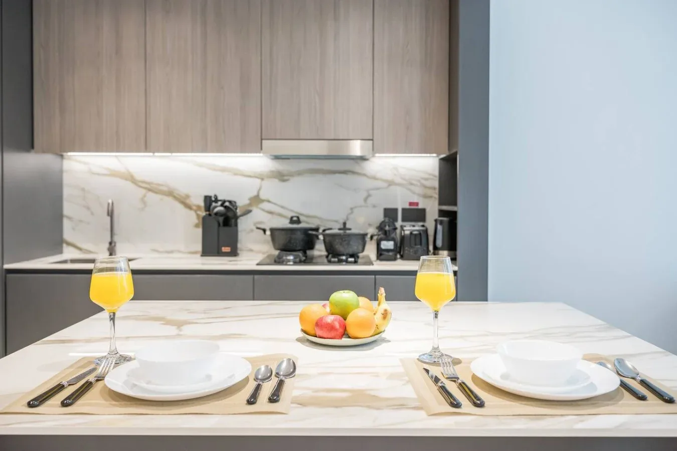Una mesa puesta con bebidas está frente a una cocina.