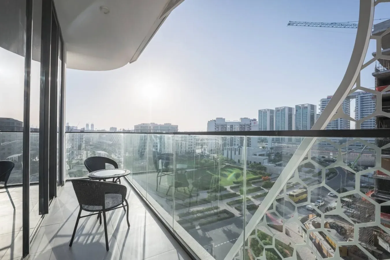 Un balcón con asientos ofrece vistas de edificios modernos y zonas ajardinadas.