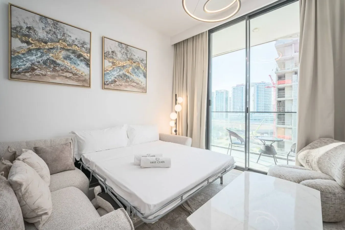 Una sala luminosa con una zona de descanso blanca junto a grandes ventanas.