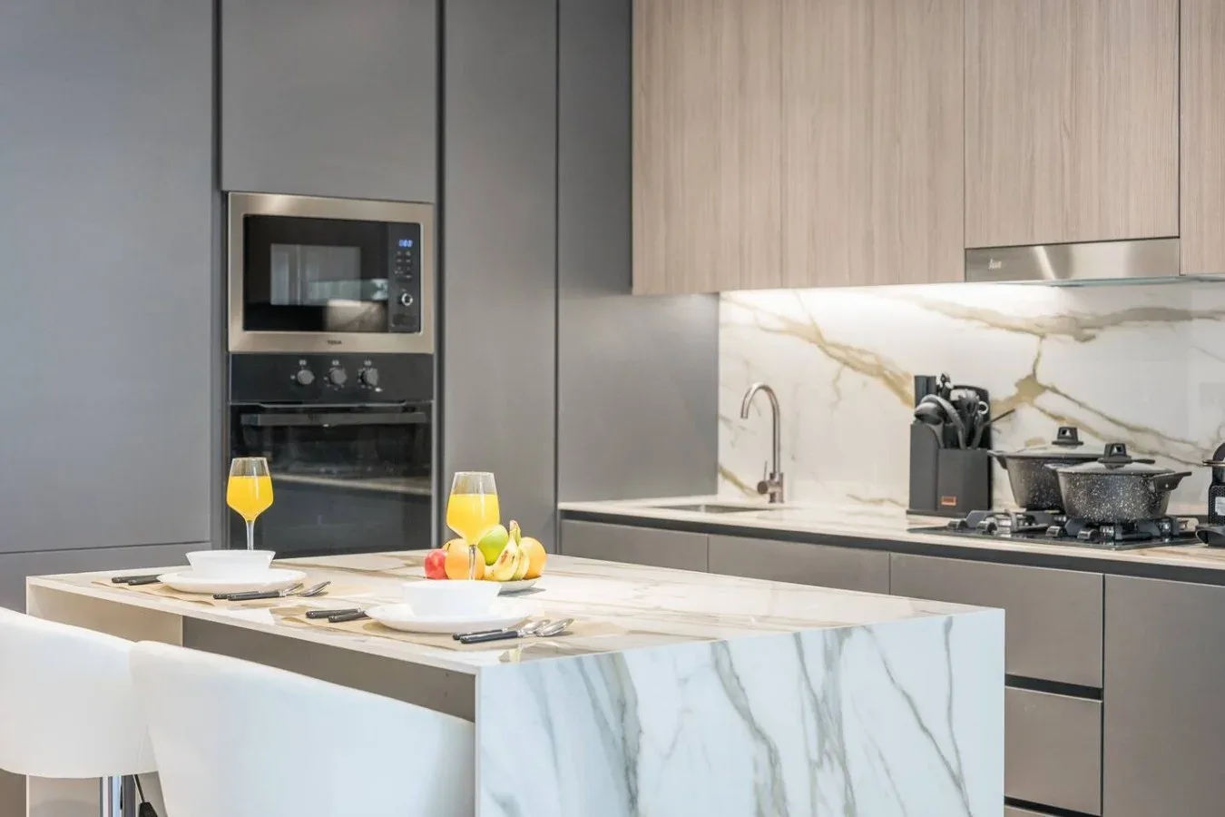 Una cocina moderna con una isla de mármol y electrodomésticos empotrados.