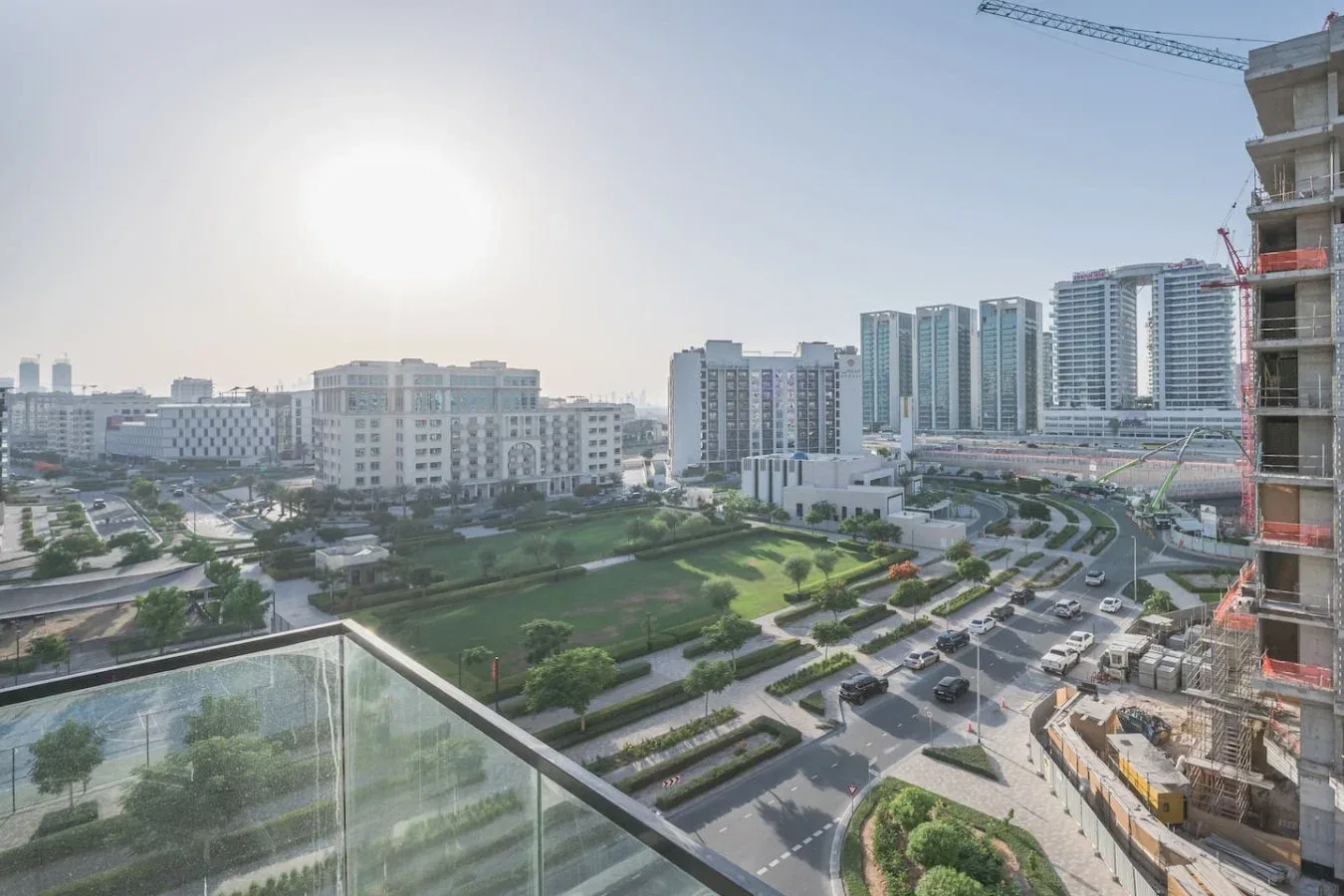 Un paisaje urbano con edificios altos, carreteras y zonas verdes ajardinadas.