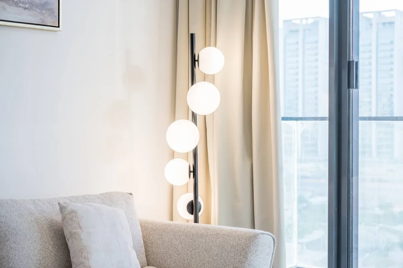 Una sala luminosa con asientos junto a una ventana alta y una lámpara de pie.
