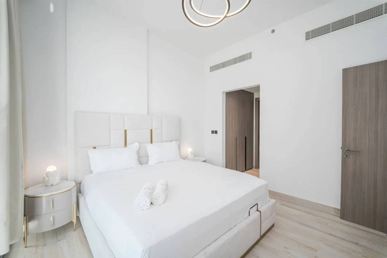 Un dormitorio luminoso con una cama grande y ropa de cama blanca.