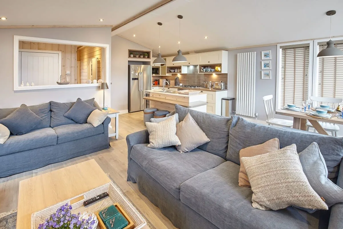 An open-plan living room with gray seating and a kitchen island.