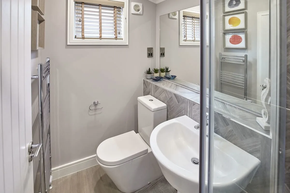A modern bathroom with a toilet and a bathtub beside a glass shower.