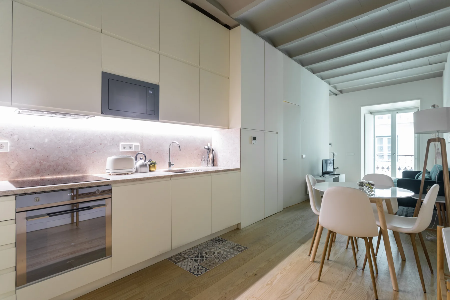 Una cocina moderna se abre a un comedor con una mesa y sillas.