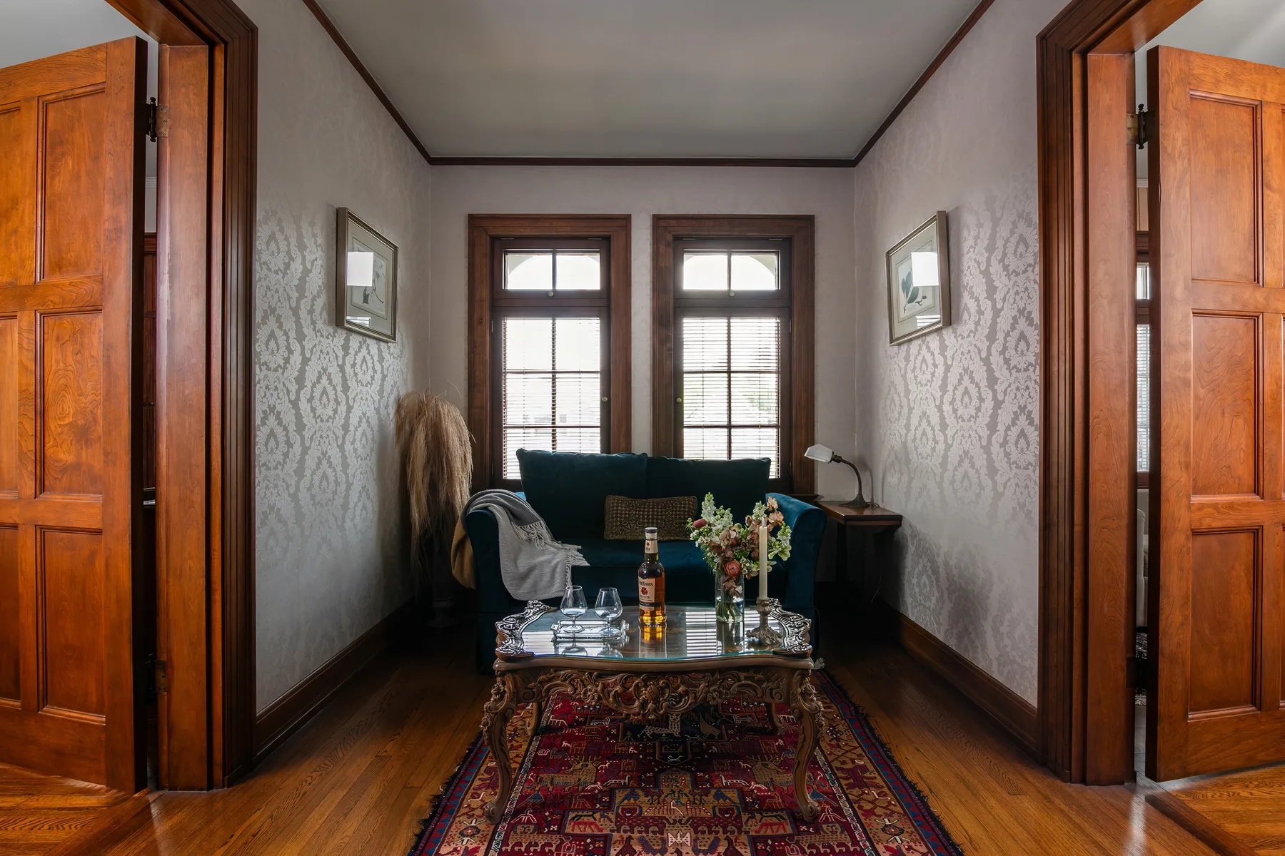 A sitting room with patterned walls and a small table in front of the seating.