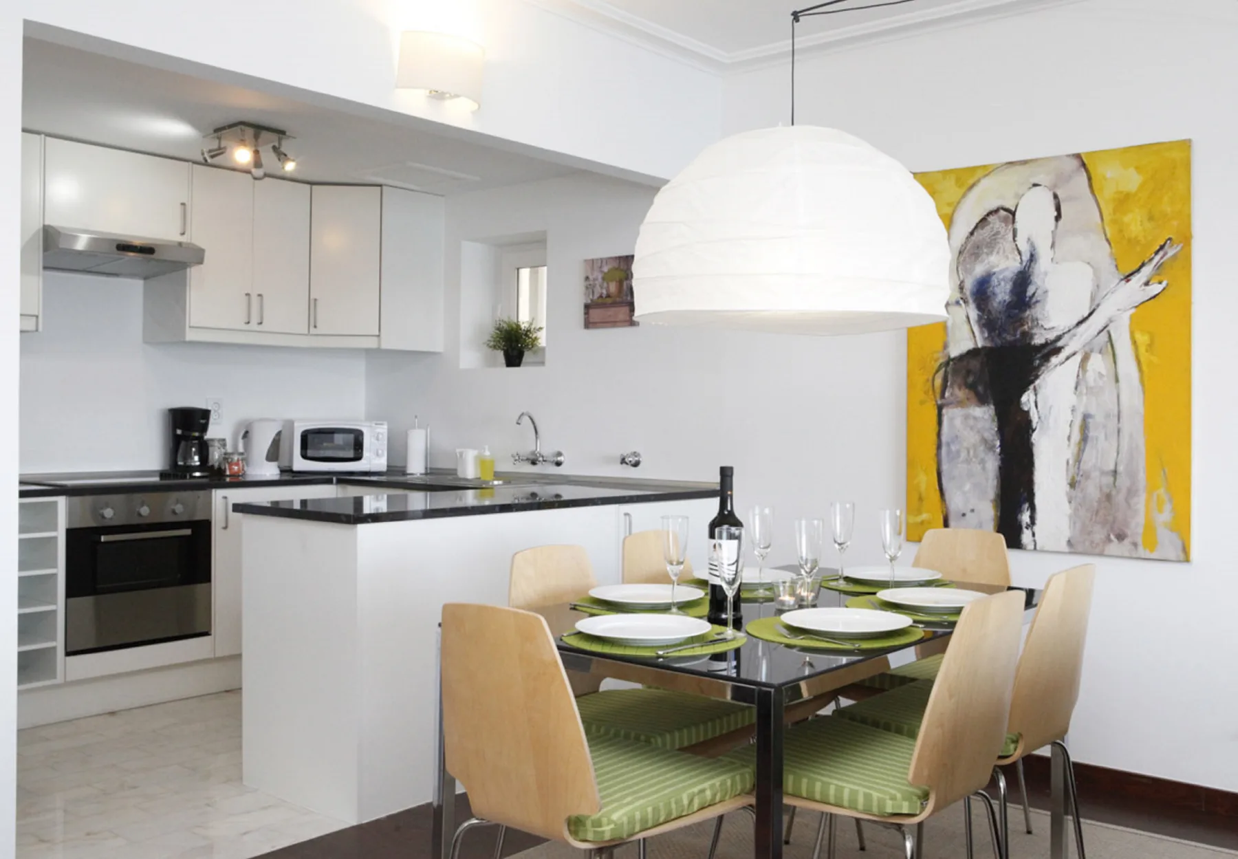 An open-plan kitchen and dining area with a table set beside the kitchen counter.