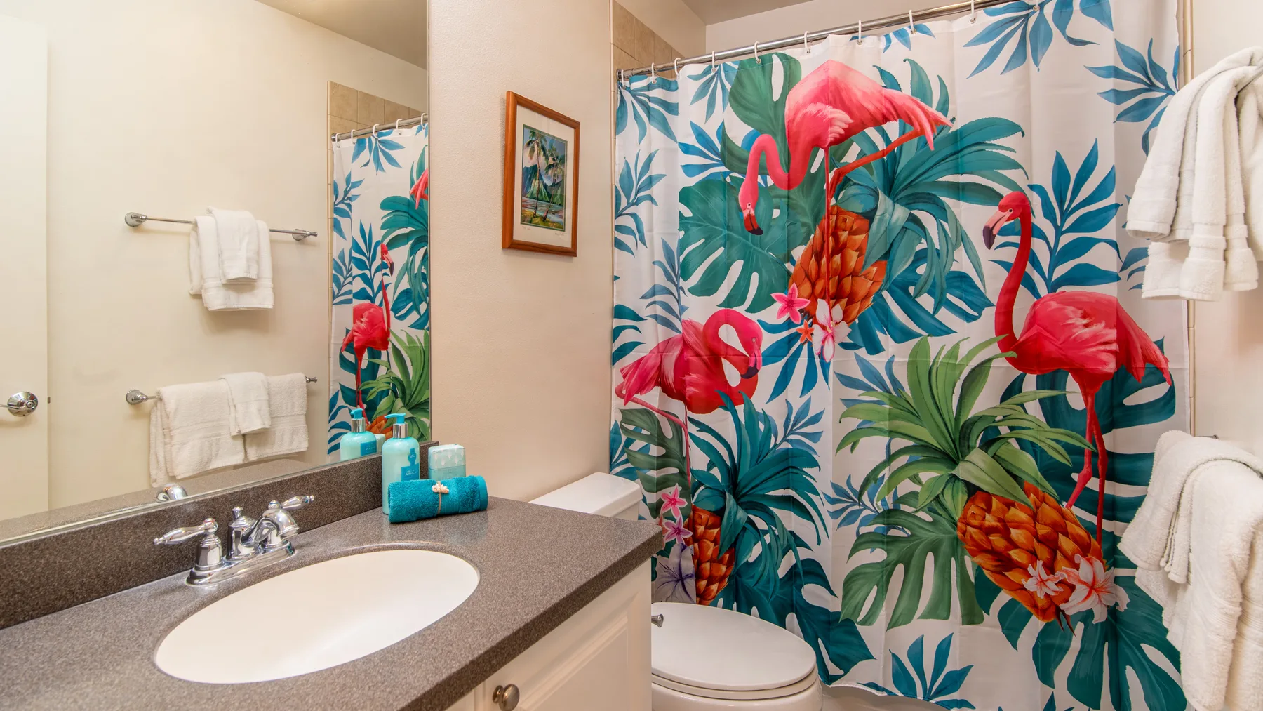 Un lavabo y un inodoro están junto a una cortina de ducha con motivos tropicales.