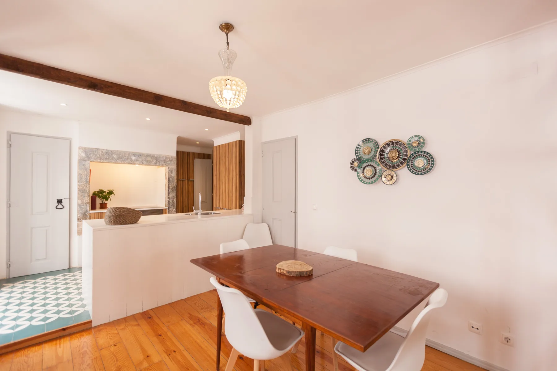 A dining area with a wooden table and open kitchen counter.