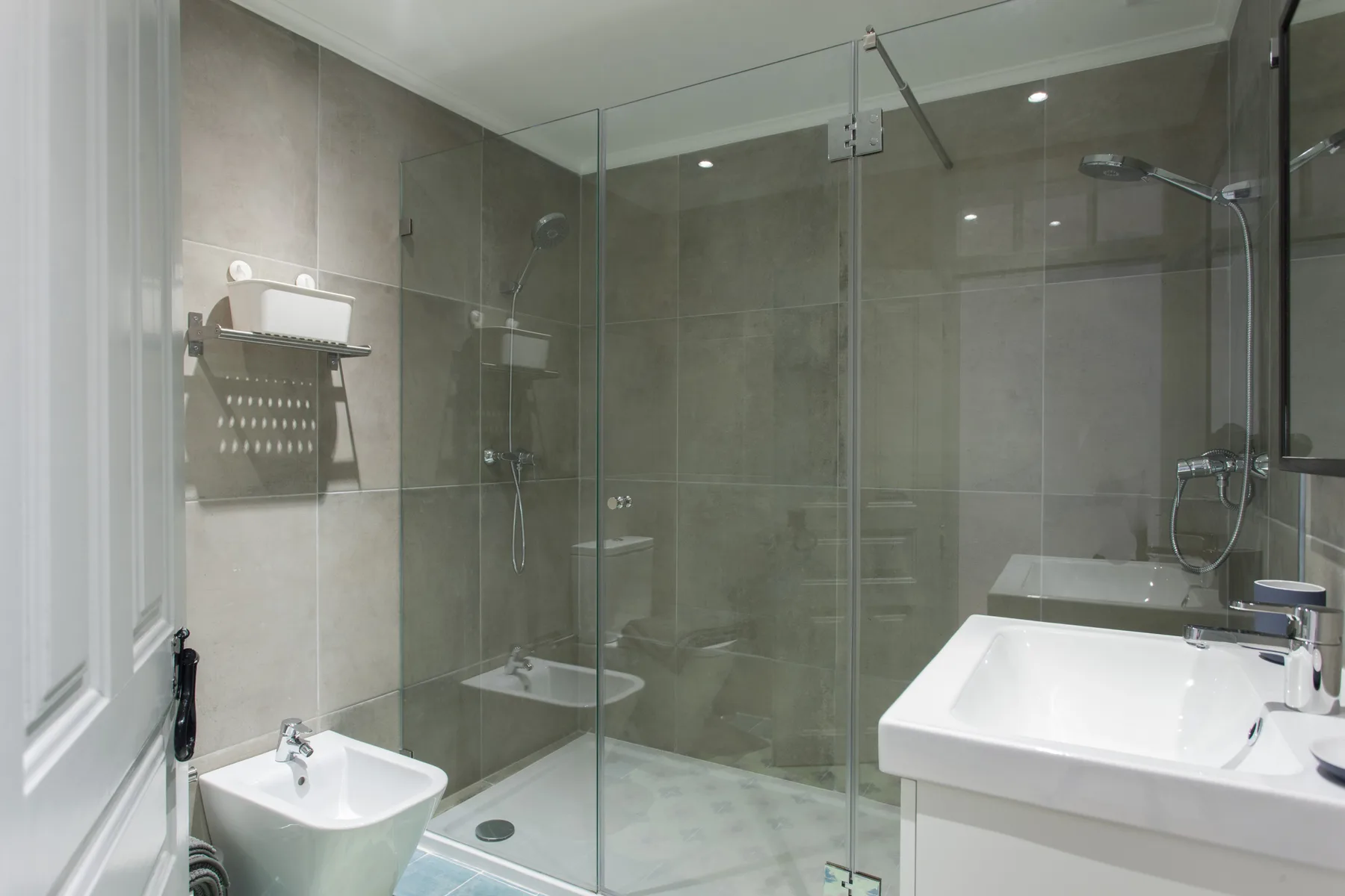 A tiled bathroom with a glass shower and white sink.