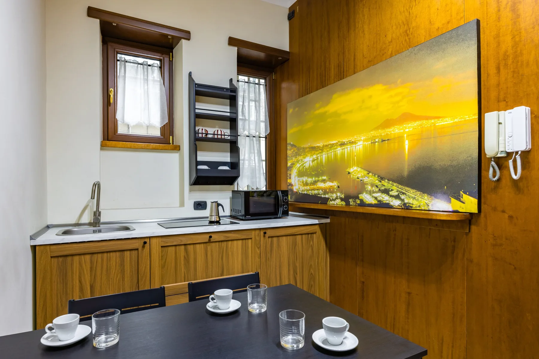 Una pequeña cocina con encimera, fregadero y mesa de comedor.