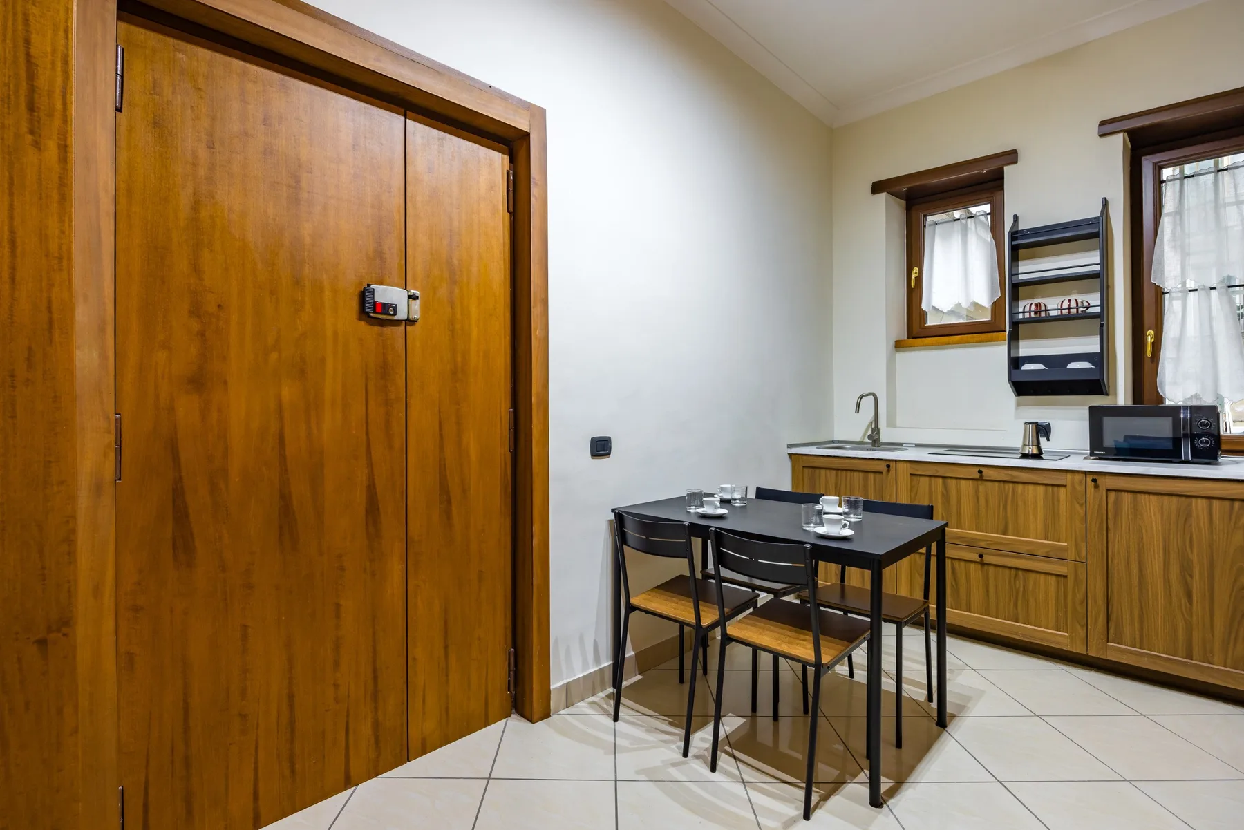 Una cocina pequeña y zona de comedor con armarios de madera y una mesa.