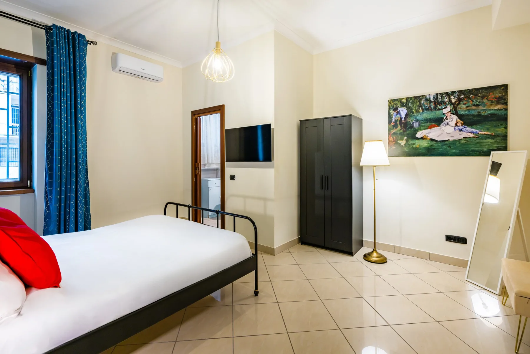 Un dormitorio con una cama, un armario y un televisor en la pared.