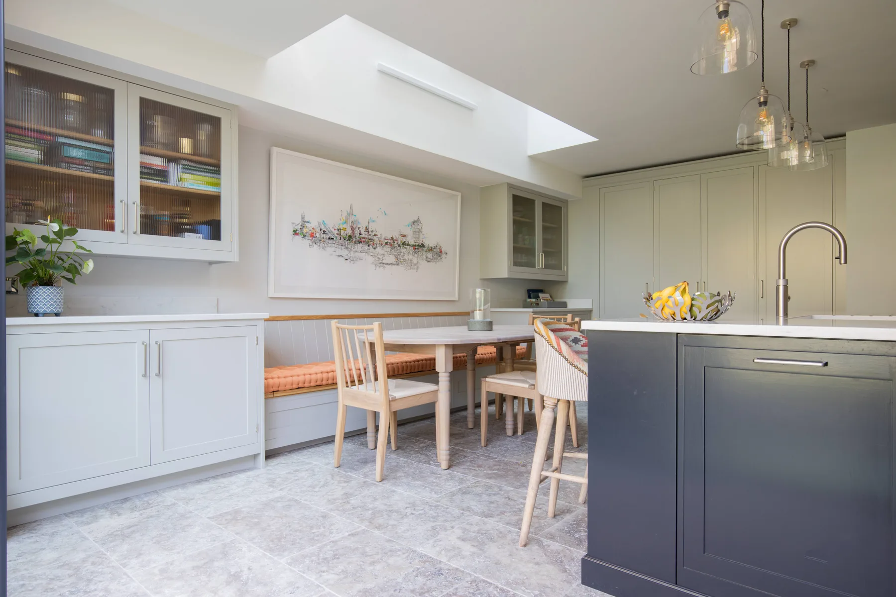 Una cocina luminosa con comedor y una mesa junto a la isla.