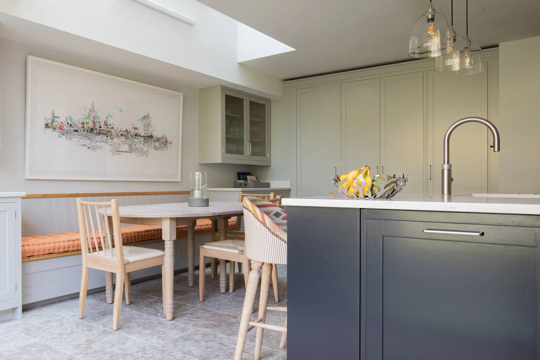 Una cocina luminosa con comedor y una mesa junto a un banco integrado.